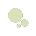 Three pastel green circular pills or tablets in varying sizes arranged diagonally across a white background