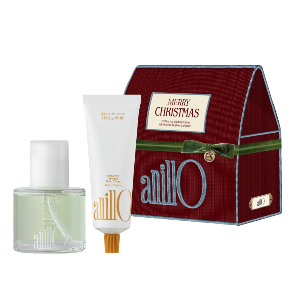 Red textured Christmas gift box with a cream-colored card reading 'Merry Christmas' and two white cosmetic tubes in front (hand cream and shower gel).