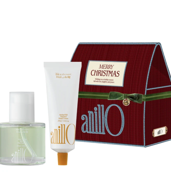 Red textured Christmas gift box with a cream-colored card reading 'Merry Christmas' and two white cosmetic tubes in front (hand cream and shower gel).