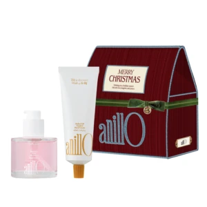 Holiday gift set featuring a red Merry Christmas box beside a white hand cream tube and a pink bottle against a white background.