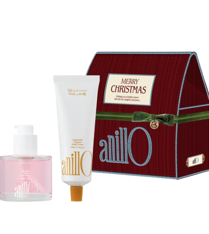 Holiday gift set featuring a red Merry Christmas box beside a white hand cream tube and a pink bottle against a white background.