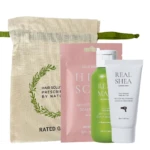 Natural hair care gift set: beige canvas pouch with green strap plus pink sachet, green bottle, and white tube labeled Real Shea