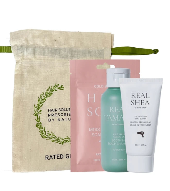 Beige fabric tote with green strap containing a hair care gift set: pink pouch, teal bottle, and white Real Shea tube.