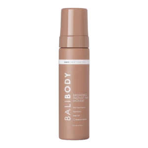 Tall bronze self-tanner mousse bottle with cap, label reads 'Dark | One Night Only' and 'Bronzing Instant Tan Mousse'