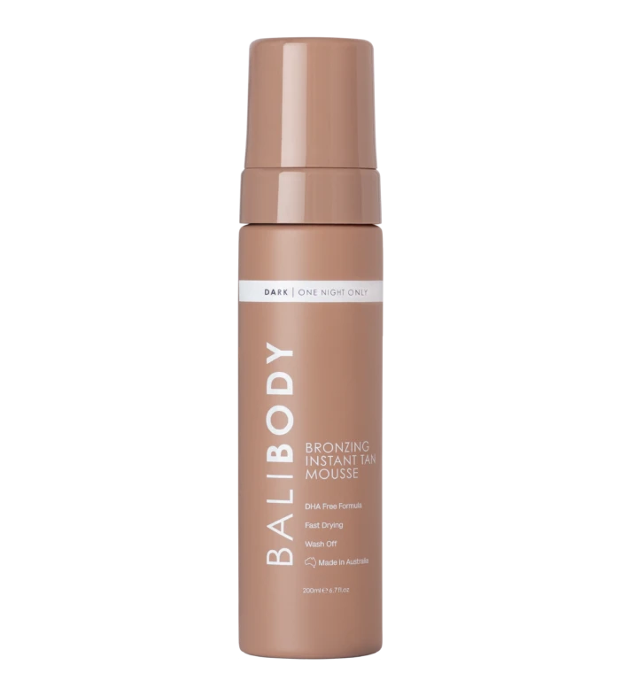 Tall bronze self-tanner mousse bottle with cap, label reads 'Dark | One Night Only' and 'Bronzing Instant Tan Mousse'