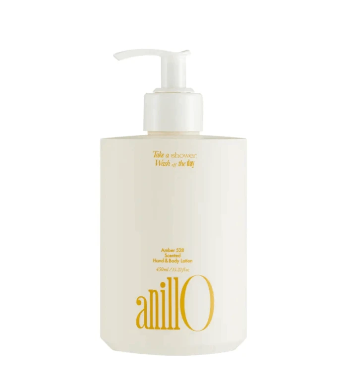White pump lotion bottle with gold text, labeled 'anill0' (Amber 528 scented hand & body lotion), single-product shot on white background.