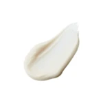 Beige cream swatch smeared on a white background, showing smooth texture and curved shape.