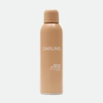 Peach-colored spray bottle with rounded cap, labeled 'DARLING', standing upright against a light background.