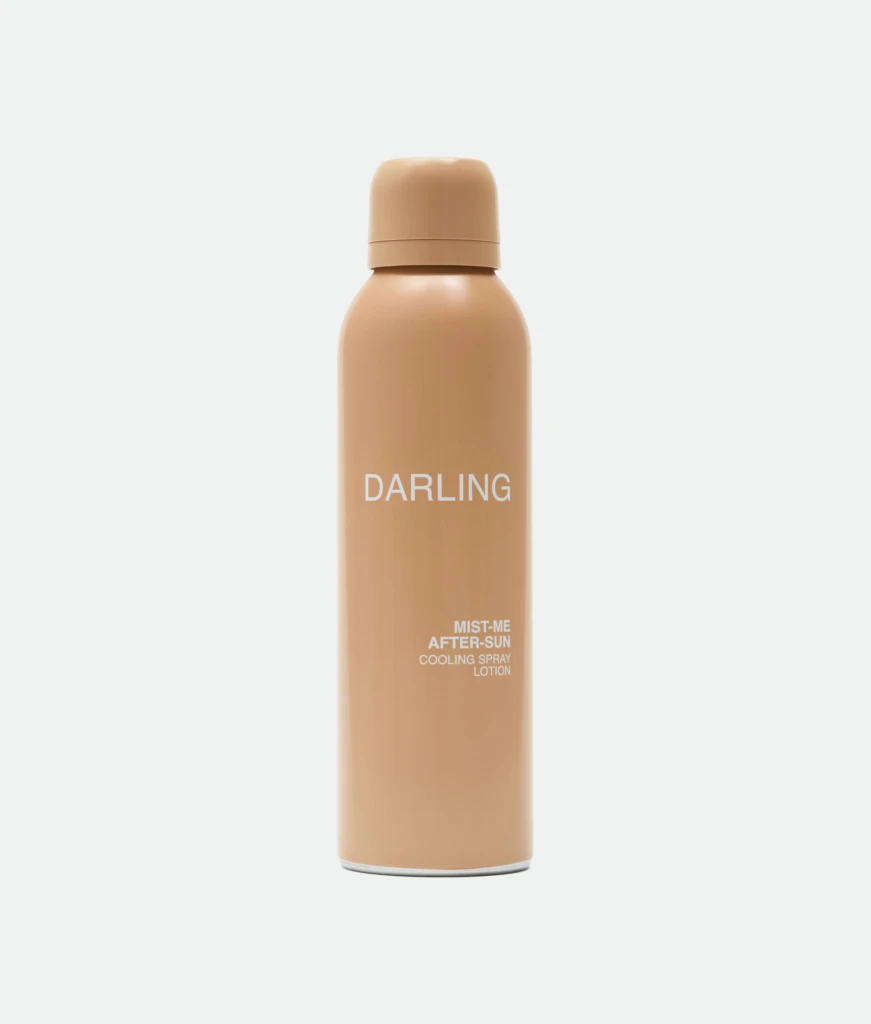 Peach-colored spray bottle with rounded cap, labeled 'DARLING', standing upright against a light background.