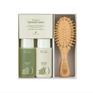 Gift set containing two AnilO hair products (shampoo and hair treatment) and a wooden bristle brush in a white box, ready as a gift