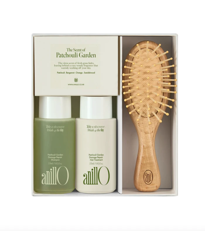 Gift set containing two AnilO hair products (shampoo and hair treatment) and a wooden bristle brush in a white box, ready as a gift