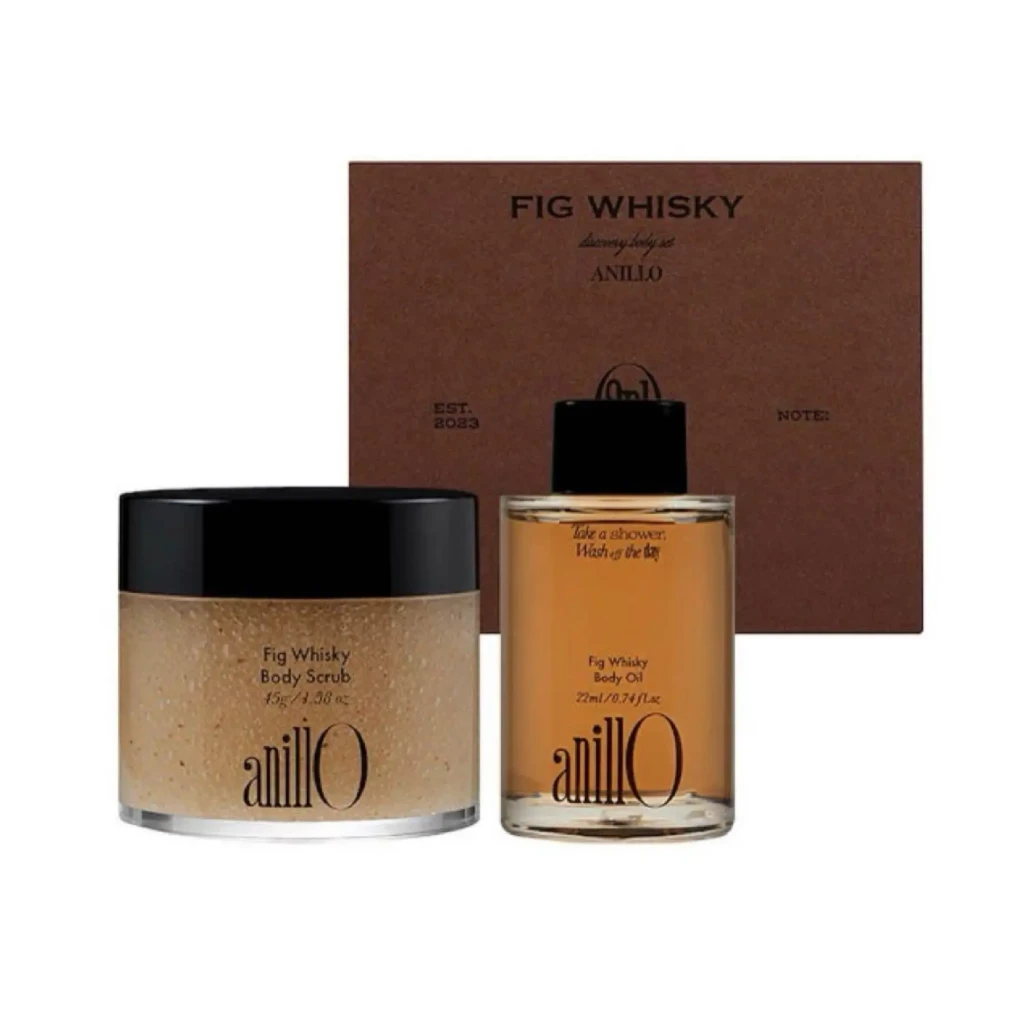 Fig Whisky skincare trio: a jar of body scrub and a bottle of body oil in front of a brown gift box.
