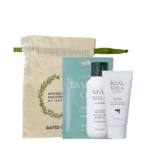 Hair care kit with a beige drawstring pouch and three Real Shea products (two bottles and a tube) in front of teal packaging behind them.