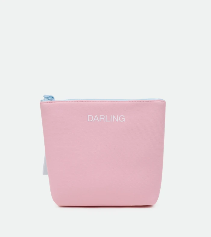Close-up of a pink zippered pouch with a light blue zipper pull and 'DARLING' printed in white on the front.