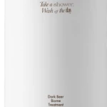 White pump bottle with a black nozzle, featuring brown text: 'Take a shower, Wash off the day' and 'Dark Beer Biome Treatment' 500 ml.
