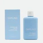 Blue Darling sunscreen bottle beside its matching light-blue box, both labeled with DARLING and SPF 50 sunscreen lotion text.