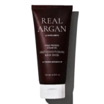 Dark brown tube of Real Arg an by Rated Green, labeled Cold Pressed Argan Oil Deep Conditioning Hair Mask with 200 ml capacity, shown against a black background with white stripes behind.