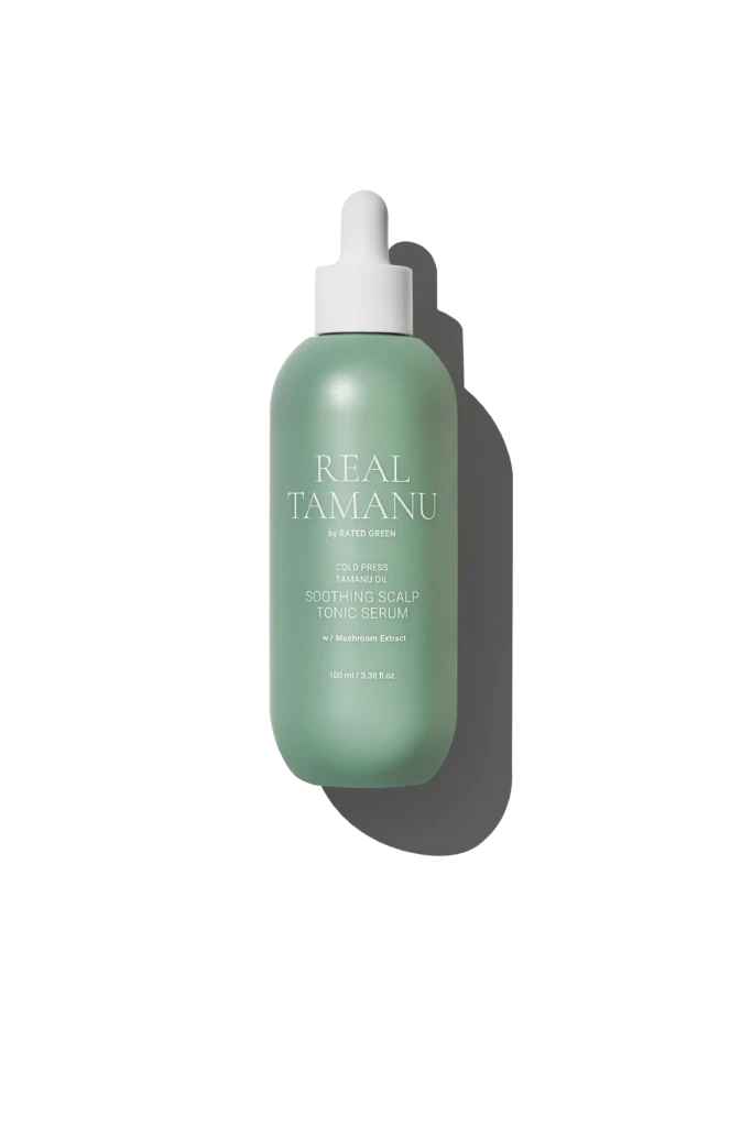 Mint-green spray bottle labeled 'REAL TAMANU' with white pump, reading 'Soothing Scalp Tonic Serum' against a black background.