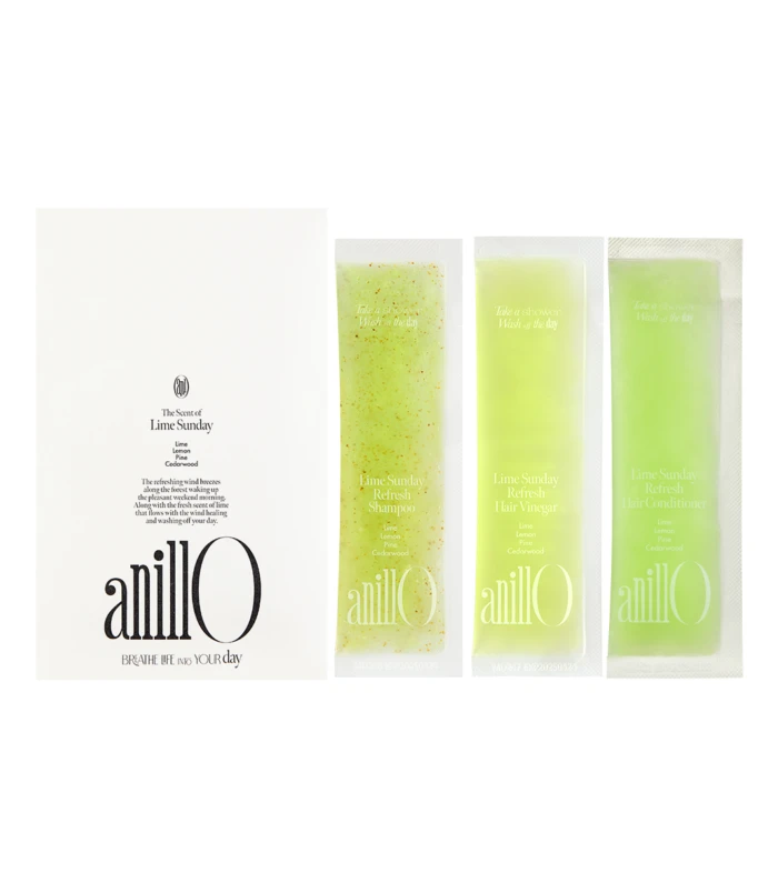 White box with the 'anillO' logo and the slogan 'BREATHE LIFE INTO YOUR day' sits beside four lime-green sachets of Lime Sunday products, from left to right including a speckled sample and three solid lime sachets labeled 'Refresh Shampoo', 'Refresh Hair Vinegar', and 'Refresh Hair Conditioner'.