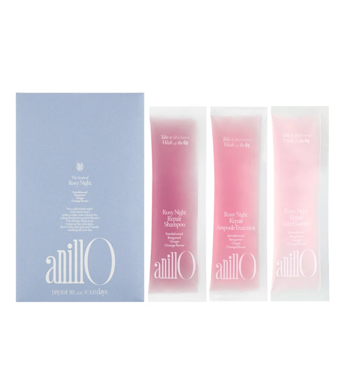 Blue box with anillo logo sits beside three pink sachets labeled Rosy Night Repair Shampoo, Ampoule Treatment, and Hair Essence on a white background.