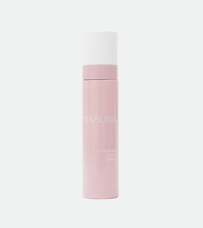 Close-up of a pink lipstick bottle with a white cap, standing upright; the word 'DARLING' appears on the container.