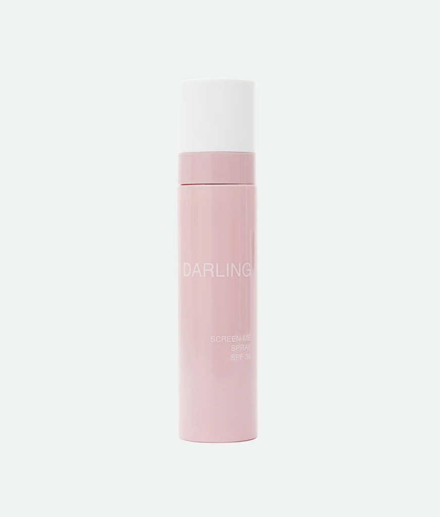 Close-up of a pink lipstick bottle with a white cap, standing upright; the word 'DARLING' appears on the container.