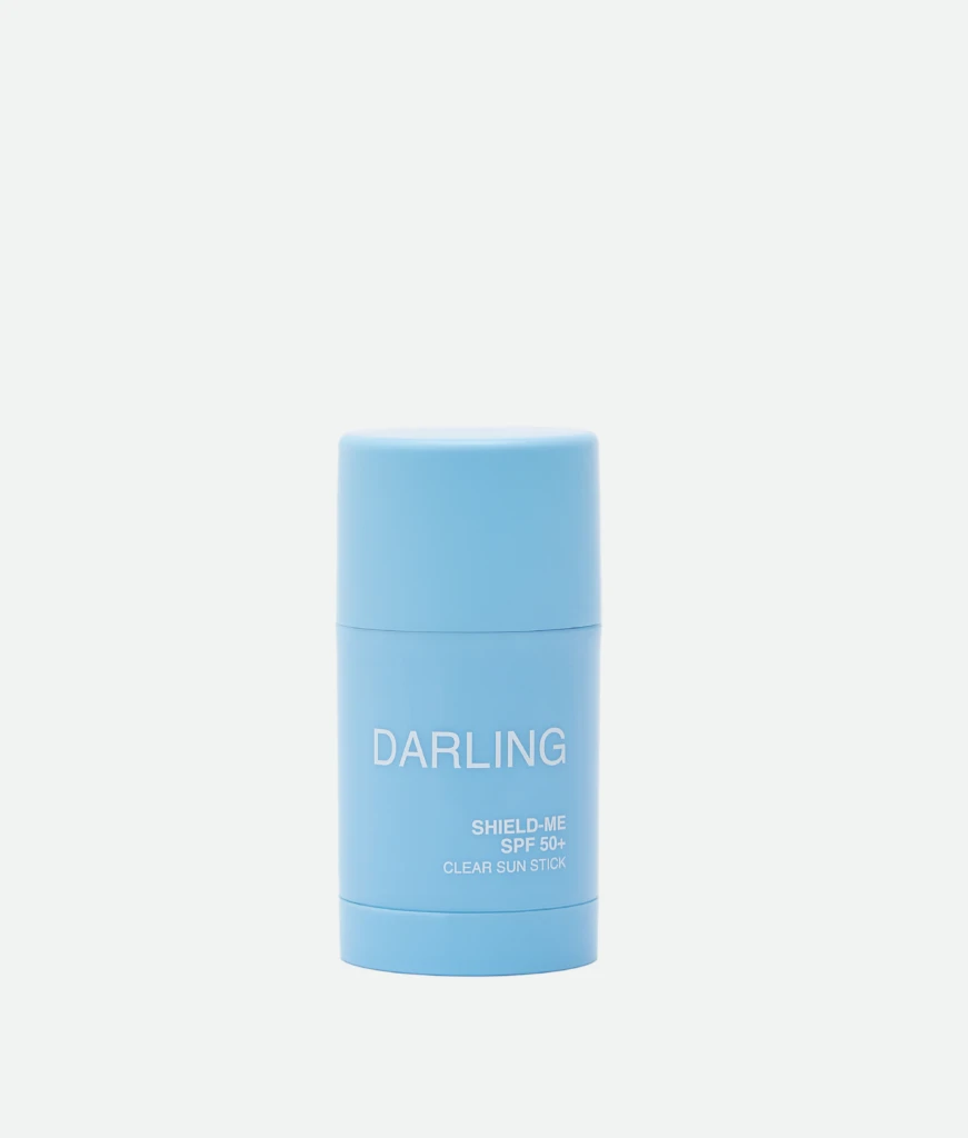 Blue cylindrical sunscreen stick labeled 'DARLING' with SPF 50+ visible on the front.