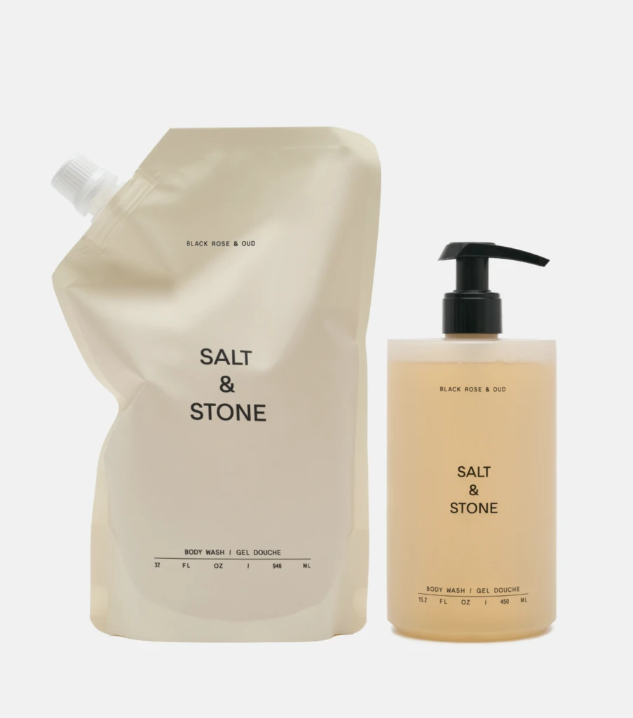 Beige Salt & Stone body wash refill pouch beside a matching pump bottle with Black Rose & Oud scent.