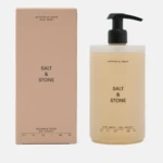 Salt & Stone body wash bottle with black pump beside a peach-colored box (Saffron & Cedar)