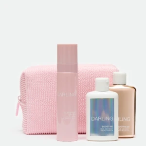Pastel pink skincare bottles arranged in front of a pink knitted bag on a white background; marketing beauty products.