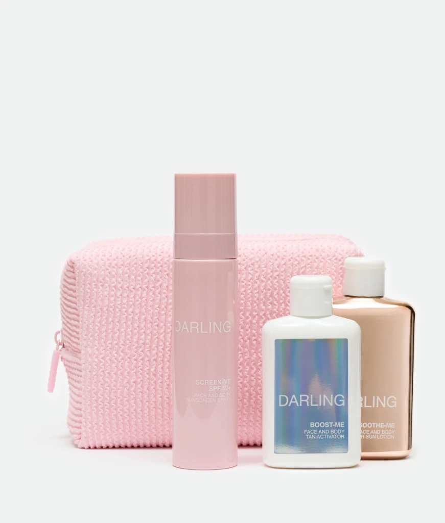 Pastel pink skincare bottles arranged in front of a pink knitted bag on a white background; marketing beauty products.