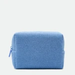 Front view of a light blue knitted zipper bag with a visible zipper pull on a pale background.
