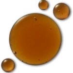 Macro image showing three orange, textured spheres on a dark background, with the largest sphere in the bottom left corner.
