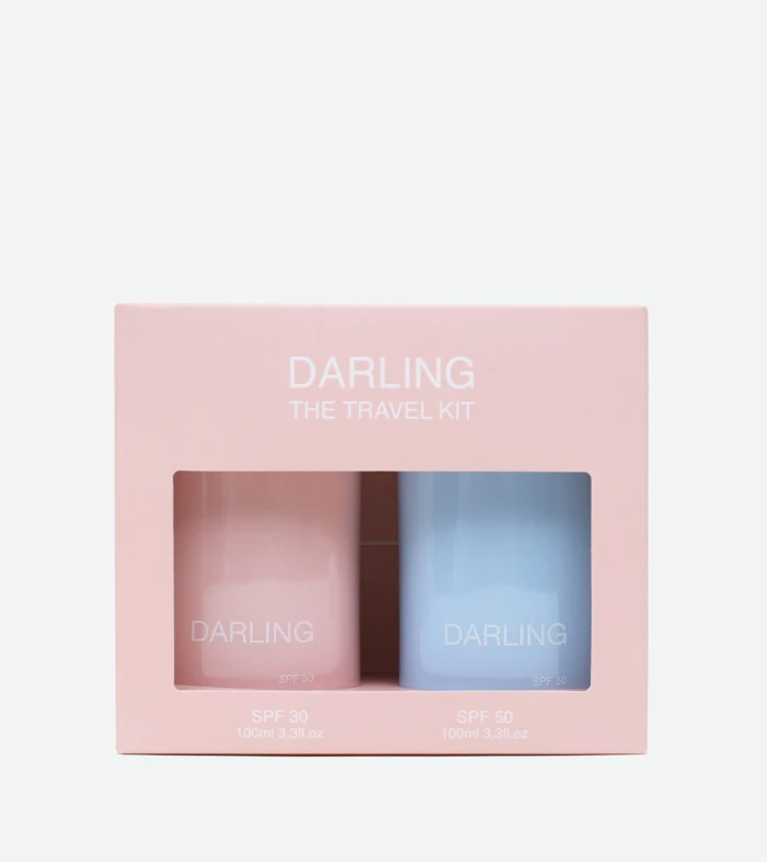 Pink travel kit box with two pastel bottles labeled DARLING, SPF 30 and SPF 50