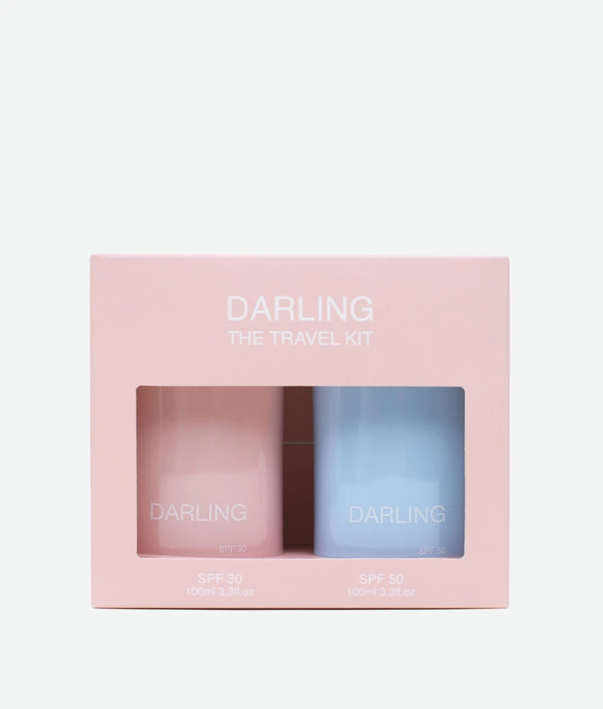 Pink travel kit box with two pastel bottles labeled DARLING, SPF 30 and SPF 50