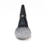 Close-up of a makeup brush tip with soft bristles against a white background.