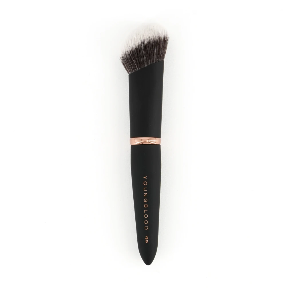 Close-up of a makeup brush with a black handle and rose-gold ferrule, bristles fanned out; 'YOUNGBLOOD' branding visible on the handle.