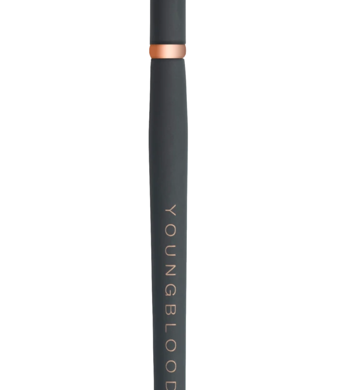 Slim black makeup brush with dense bristles, rose-gold collar, and 'YOUNGBLOOD' printed along the handle.