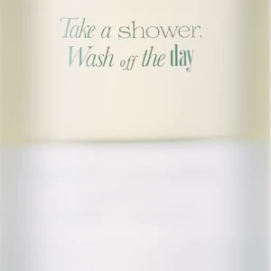 Tall white bottle with a frosted cap, labeled Neroli Wood Glow Hair Mist (70 mL) and the slogan 'Take a shower, Wash off the day'.