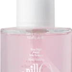 Close-up of a pink cosmetic bottle with a white cap, displaying the label 'Rosy Night Repair Hair Essence'.