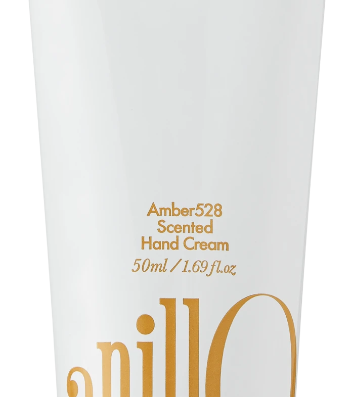 White hand-cream tube with orange lettering, reading 'Amber528 Scented Hand Cream' and '50ml / 1.69 fl. oz', bottom orange cap; includes a decorative wordmark along the side and the phrase 'Take a shower, Wash off the day' near the top.