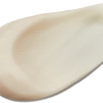 Close-up of a pale fingernail with a smooth curved edge on a beige background.