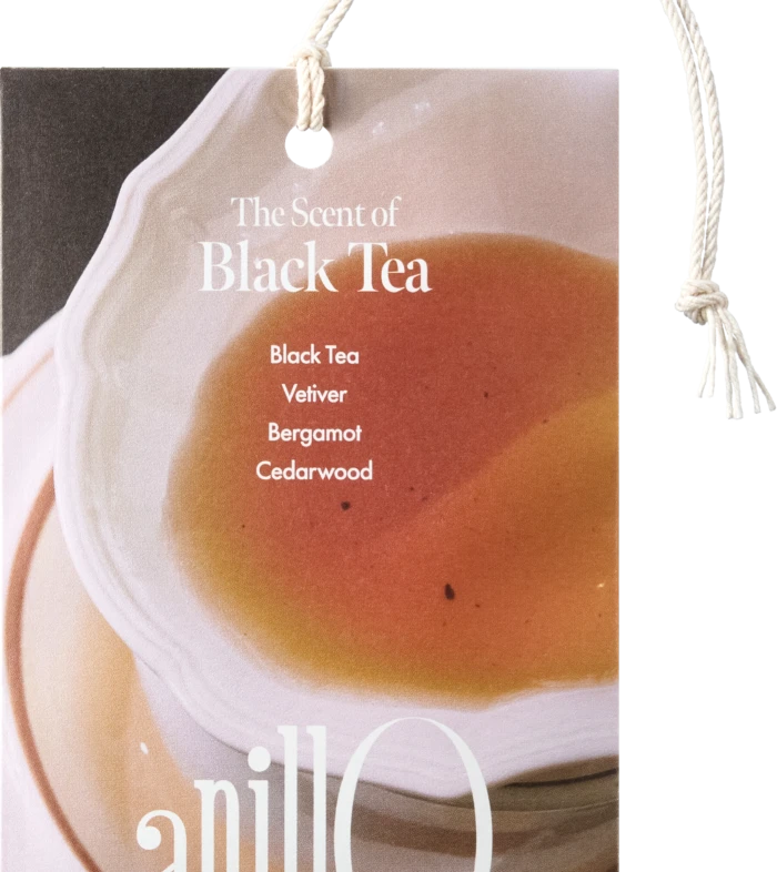 Product tag reading 'The Scent of Black Tea' with notes Black Tea, Vetiver, Bergamot, Cedarwood, attached by a rope.