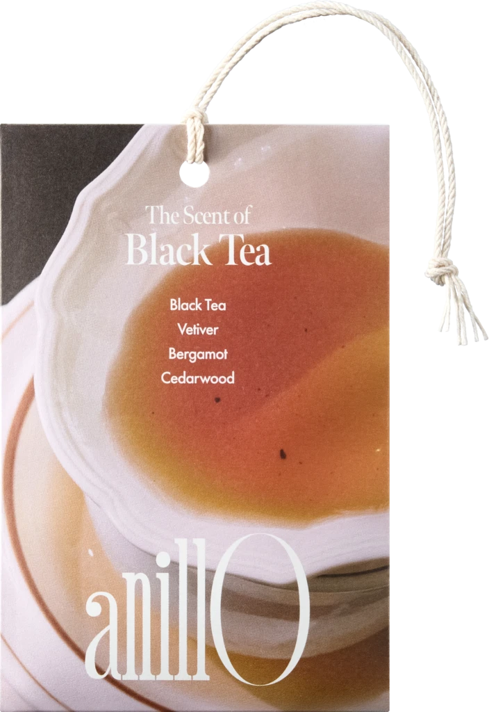 Product tag reading 'The Scent of Black Tea' with notes Black Tea, Vetiver, Bergamot, Cedarwood, attached by a rope.