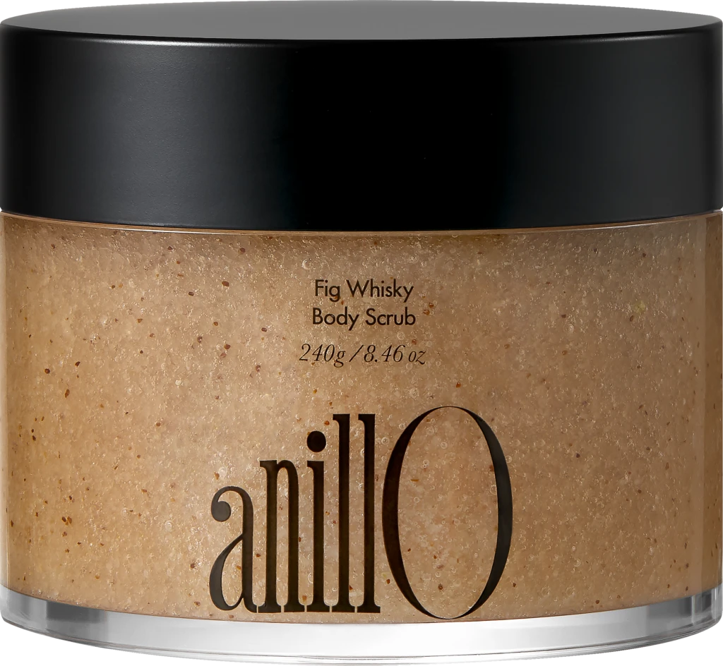 Close-up of a jar with a black lid containing Fig Whisky Body Scrub; beige, speckled scrub visible.