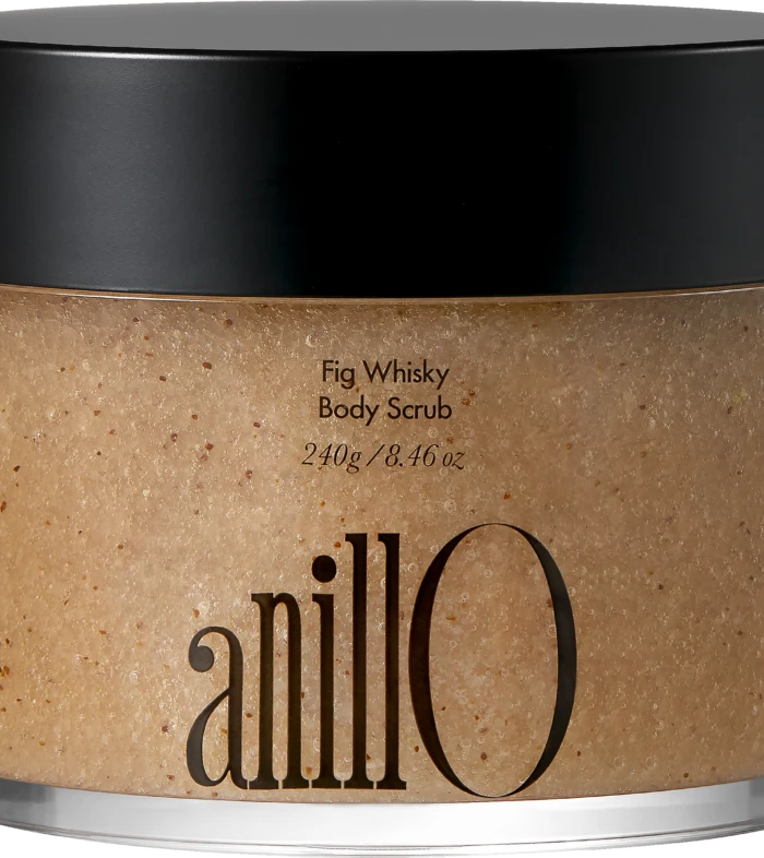 Close-up of a jar with a black lid containing Fig Whisky Body Scrub; beige, speckled scrub visible.