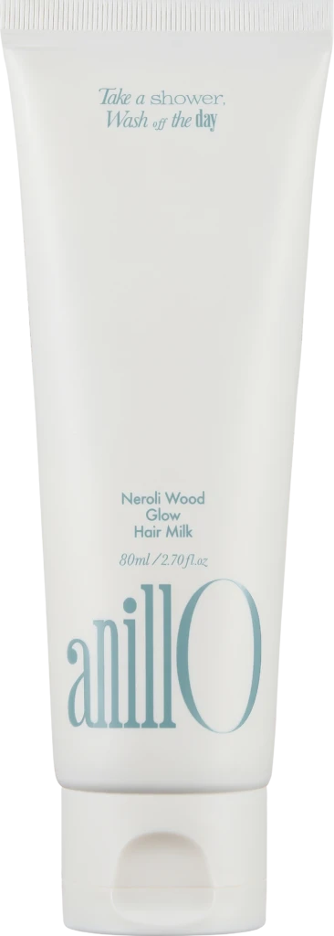 White hair milk tube labeled Neroli Wood Glow Hair Milk with blue slogan 'Take a shower, Wash off the day' and a large blue 'anillo' logo on the side.