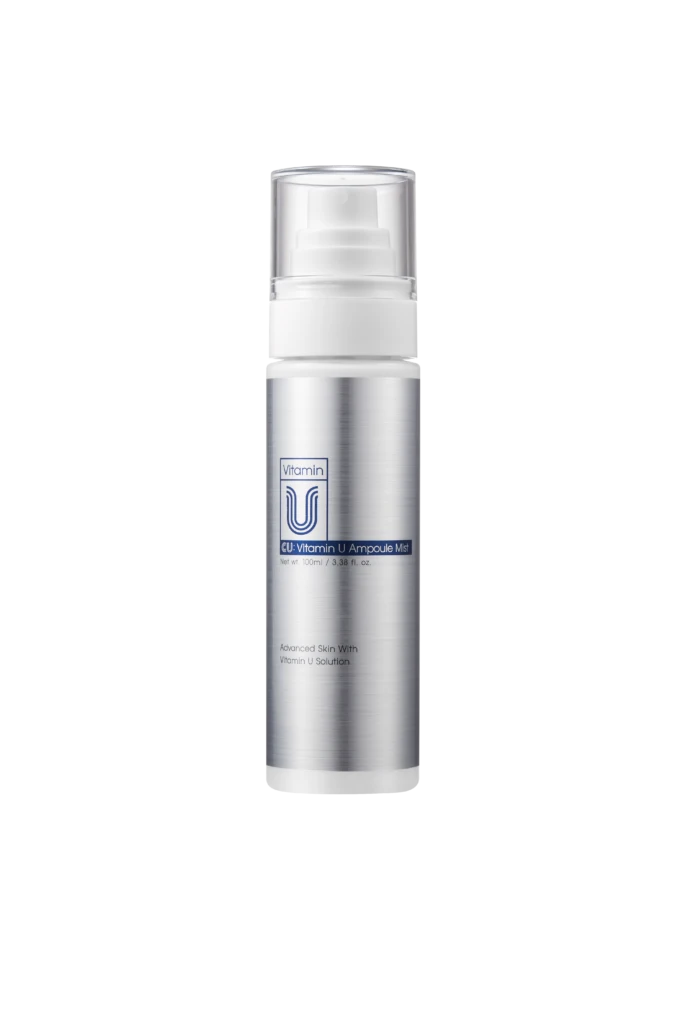Silver cosmetic spray bottle with a clear cap, labeled 'Vitamin U Ampoule Mist,' set against a black background.