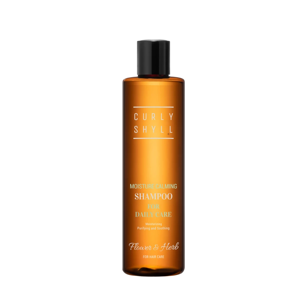 Orange shampoo bottle with a black cap, label reading 'Moisture Calming Shampoo for daily care' and brand 'Flower & Herb'.