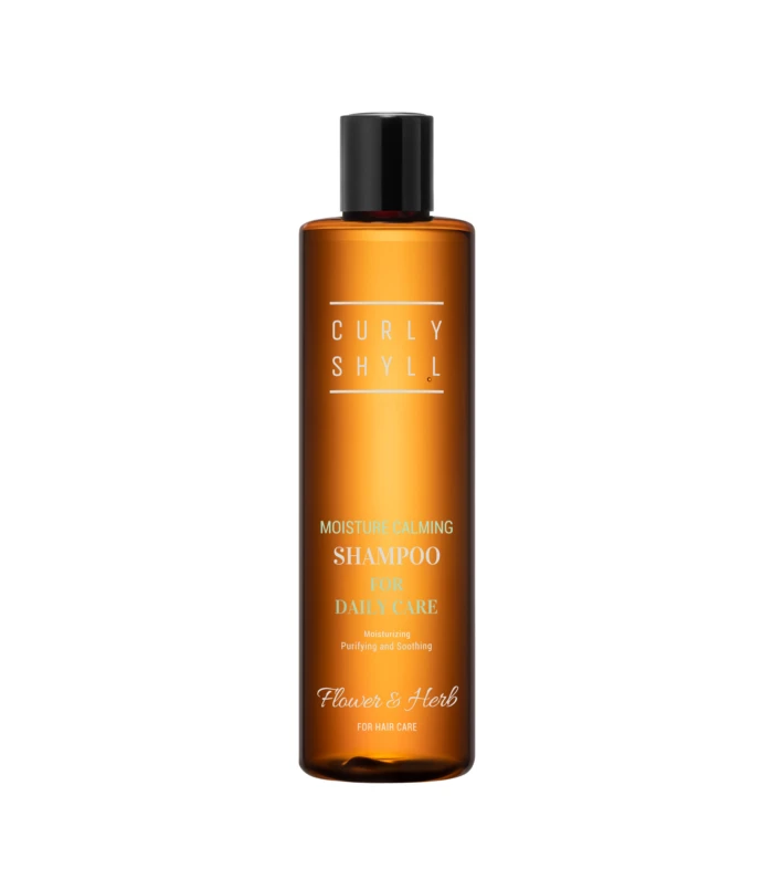 Orange shampoo bottle with a black cap, label reading 'Moisture Calming Shampoo for daily care' and brand 'Flower & Herb'.